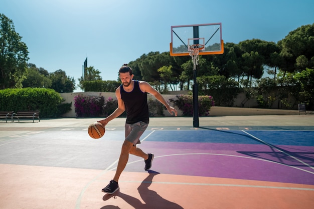 Basketbalspeler traint zichzelf op een basketbalveld met een bal