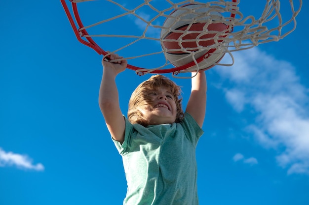 Basketbalspeler voor kinderen maakt slam dunk actieve kinderen genieten van buitenspel met basketbal