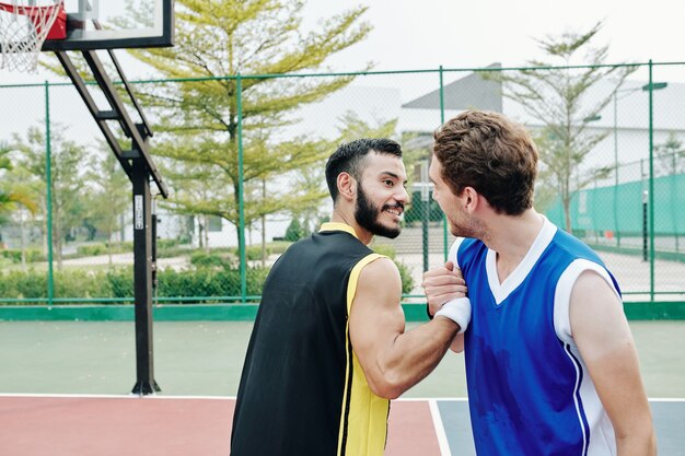 Basketbalspelers die handen schudden