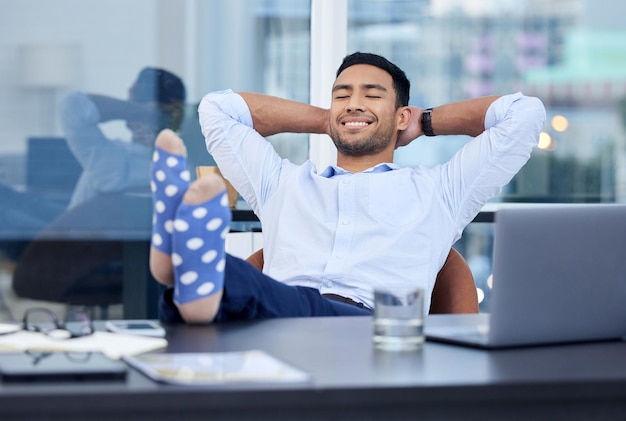 Basking in glory Shot of a very satisfied businessman relaxing at his desk at work