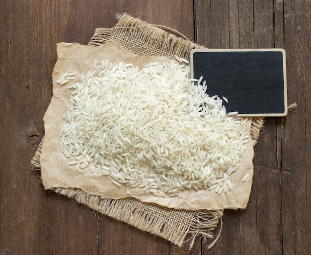 Basmati rauwe rijst op hout met een klein bord bovenaanzicht