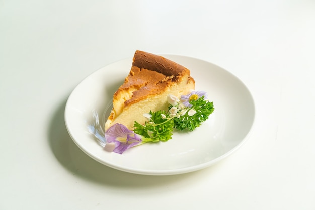 Basque Burnt Cheesecake decoratoin with flowers on white plate