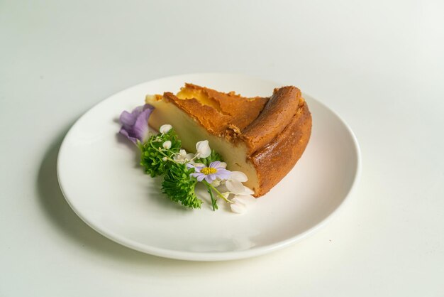 Basque Burnt Cheesecake decoratoin with flowers on white plate