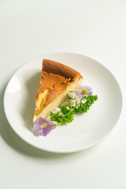 Basque Burnt Cheesecake decoratoin with flowers on white plate