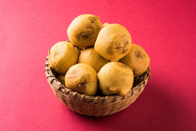 Batata Vada or Aloo Bonda is a tasty and popular indian tea-time snack served with green chillies and tomato ketchup. Selective focus