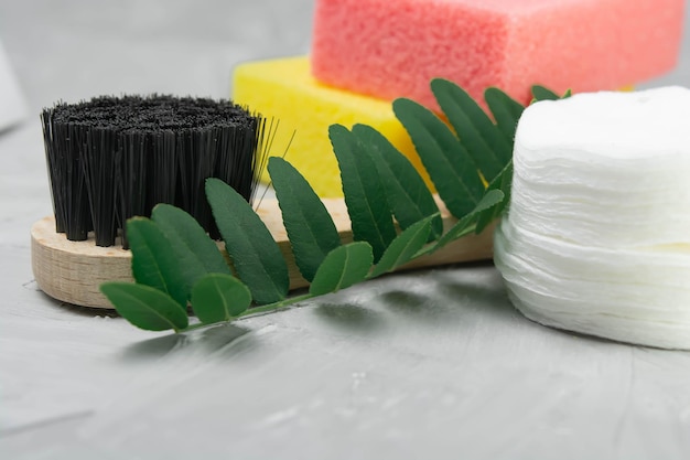 Bath accessories on a gray background, penza, brush, basket and flowers