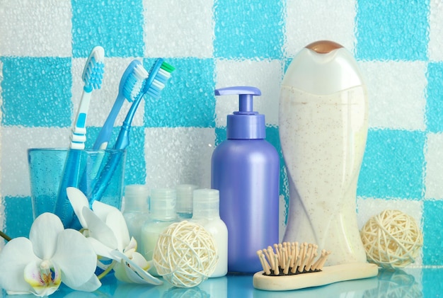 Bath accessories on shelf in bathroom on blue tile wall background