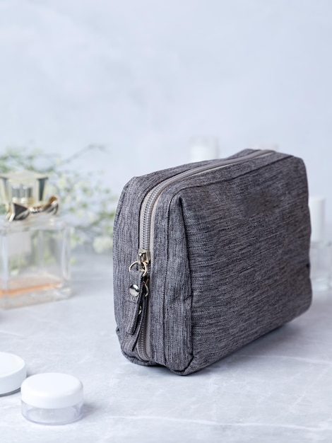 Accessori da bagno borsa da toilette borsa cosmetica grigia con cerniera con fiori e profumo sullo sfondo