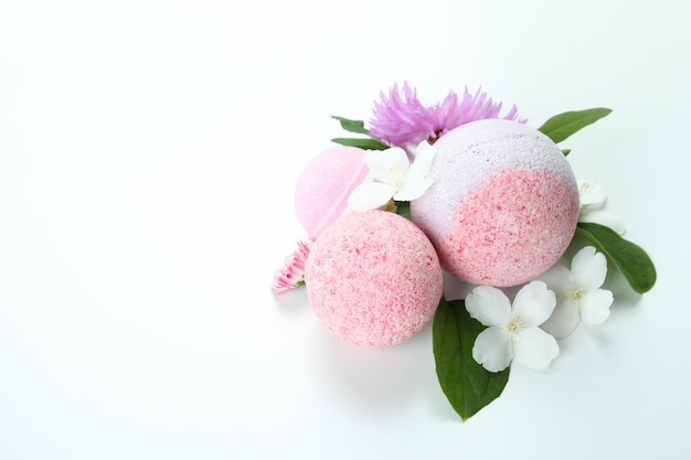 Bath balls and flowers on white background, space for text