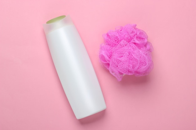 Bath, beauty products on a pink. Shampoo bottle and sponge