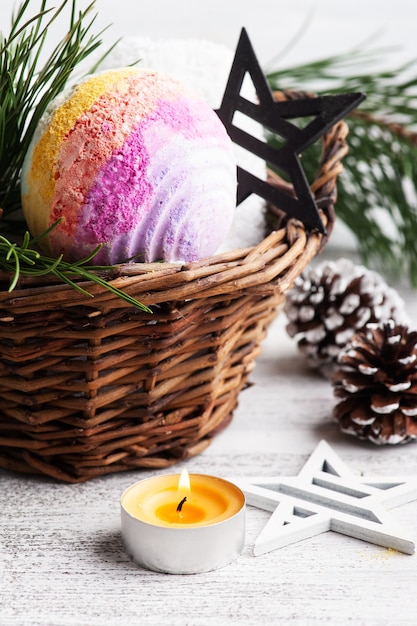 Bath bomb in basket in Christmas SPA composition with pine tree branches and stars