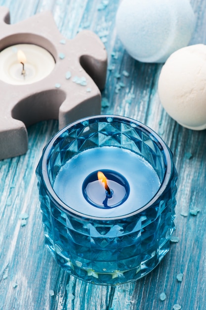 Ванна бомбы крупным планом с голубой зажженной свечой