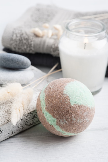 Bath bombs and towels with lit candle