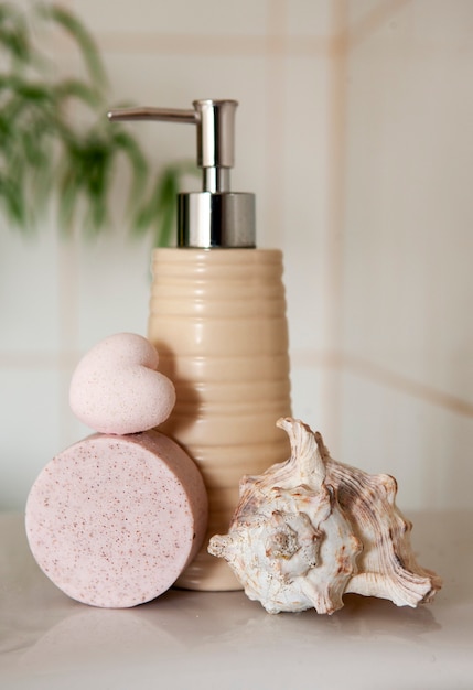 Bath ceramic bottle, soap, shell and bath bomb on Blurred bathroom interior background with sink