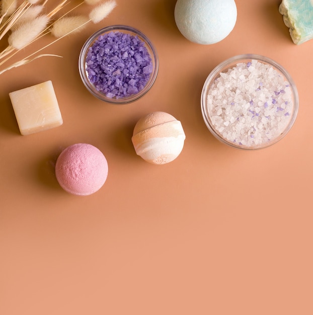 Bath cosmetics. Salt, bath bombs and soap on a brown background. Copy space. View from above