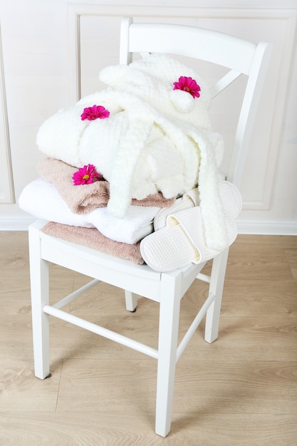 Photo bath set with white bathrobe on chair, indoors