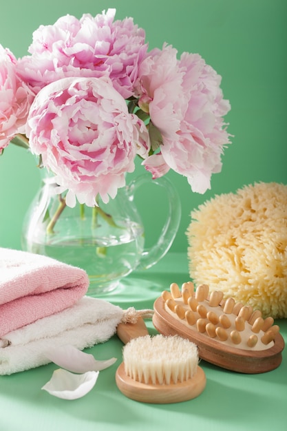 Bagno e spa con fiori di peonia spazzolano asciugamani di spugna