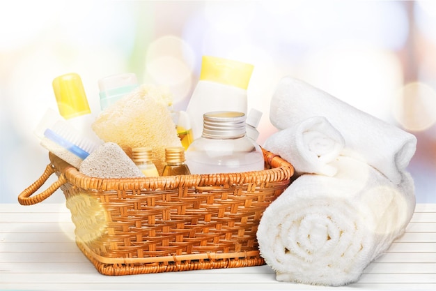 Bath towel and basket with accessories for spa on blur background