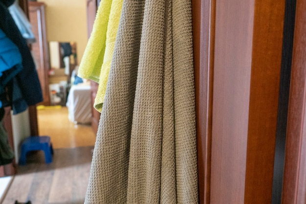 Bath towels hang on the open door. Blurred background of the room interior in the background