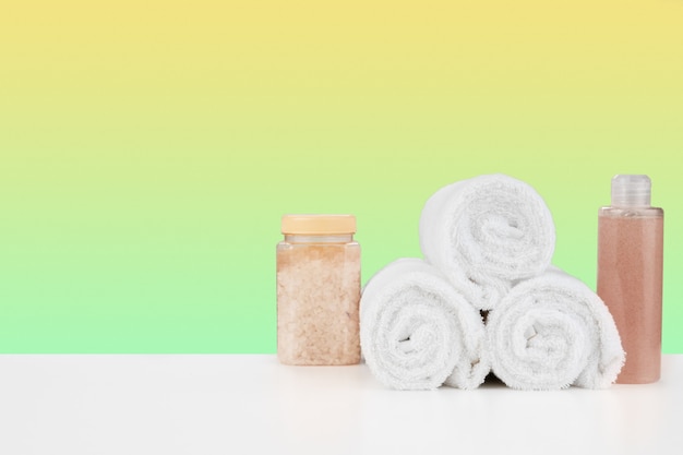 Bath towels and spa salt on white table