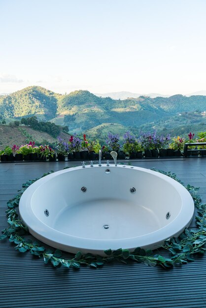 Bath tub on balcony with mountain hill background