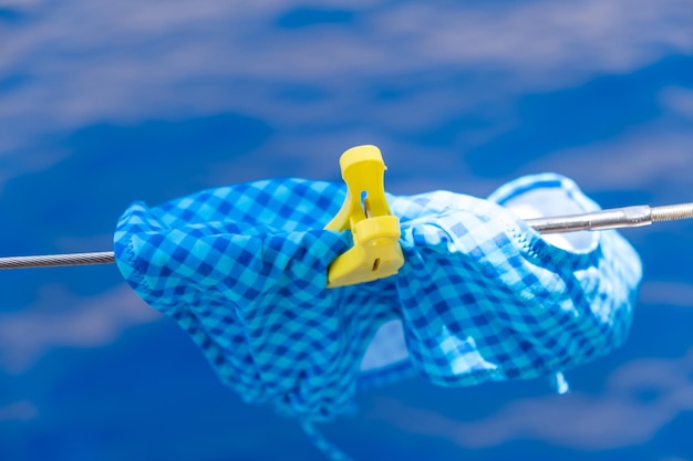 Bathing suit drying on clothesline blur sea background