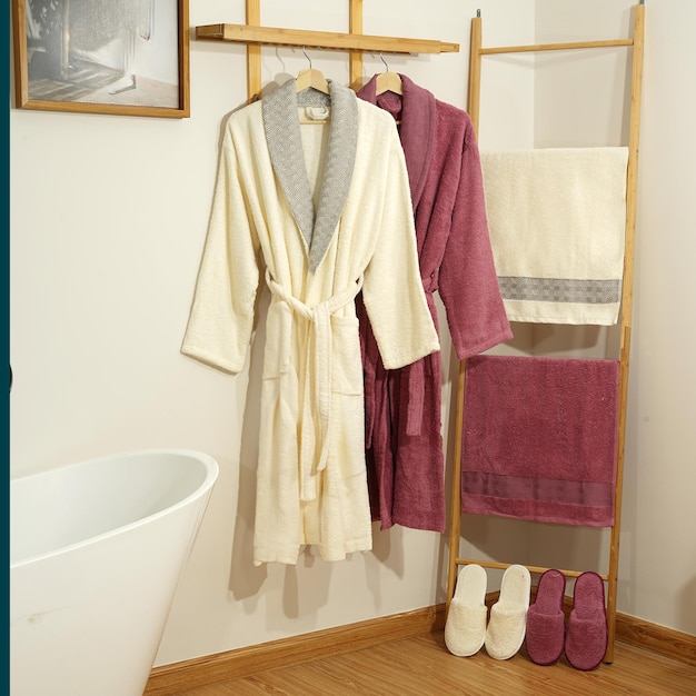 Bathrobe set Hanger with clean bathrobe and towel on light wall bathrobe mockup