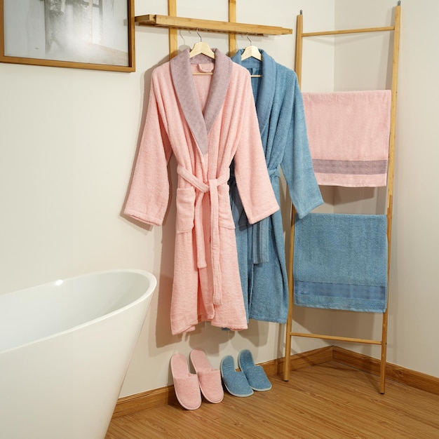 Bathrobe set Hanger with clean bathrobe and towel on light wall bathrobe mockup