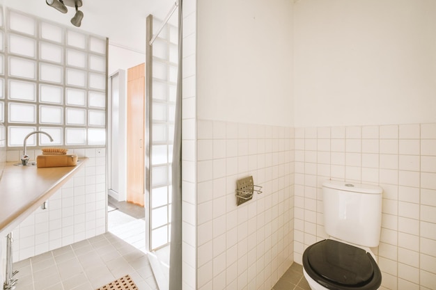 Bathroom interior surrounded by tiles in a modern house with toilet