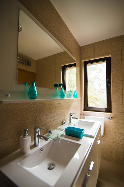 Ванная комната интерьер умывальник биде унитаз большое зеркало стены светло-коричневого цвета
