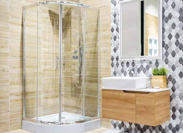 Photo bathroom interior with a shower cabin with glass wall, a toilet and faucet sink