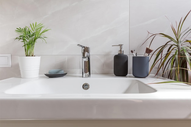 Bathroom interior with sink washbasin soap and green tropical plants Modern bathroom design