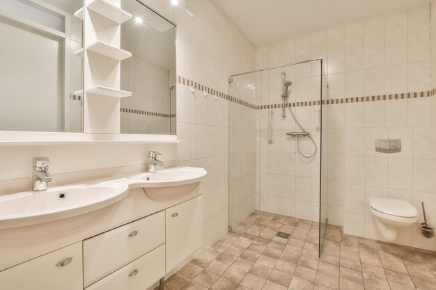 Bathroom interior with white and beige tiles in a modern house with double sink and glass shower