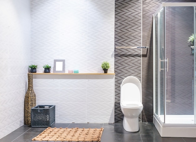 Bathroom interior with white walls, a shower cabin with glass wall, a toilet and sink