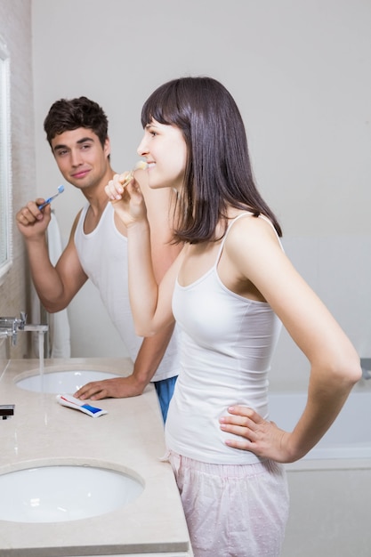 Bathroom routine for happy young couple brushing teeth