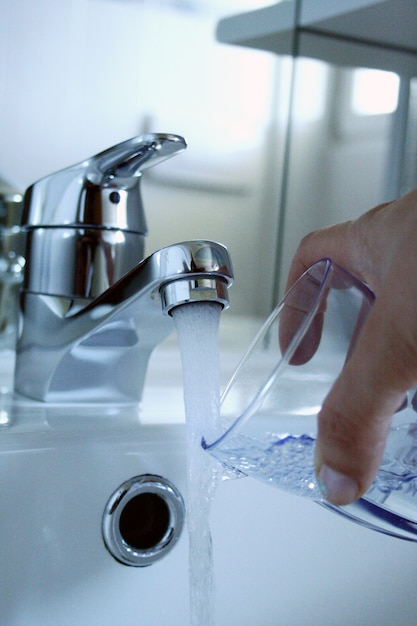 bathroom sink with water coming down from the tap