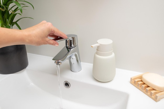 Раковина в ванной женщина рука закрыть кран экономическая вода