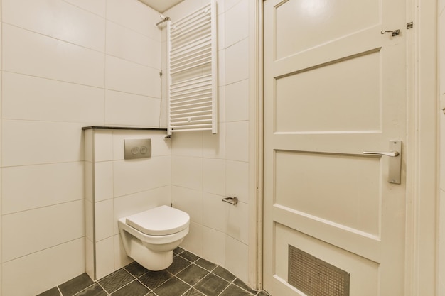 Bathroom with black tiles on the floor and a hinged toilet