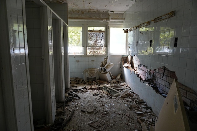 壊れた壁とその中にトイレのあるバスルーム