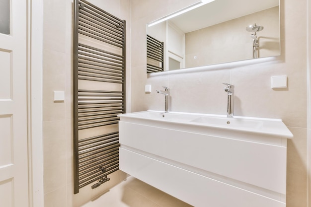 モダンで居心地の良い家の大きな鏡の下にあるダブルセラミックシンク付きのバスルーム