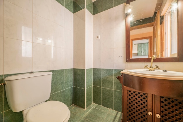 Bathroom with light colored wooden cabinets and reddish and cream colored tiles