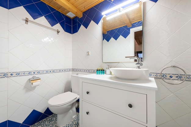 Bathroom with white wooden cabinet with drawers white resin sink and frameless mirror above sink walkin shower with screen and wooden coffered ceiling