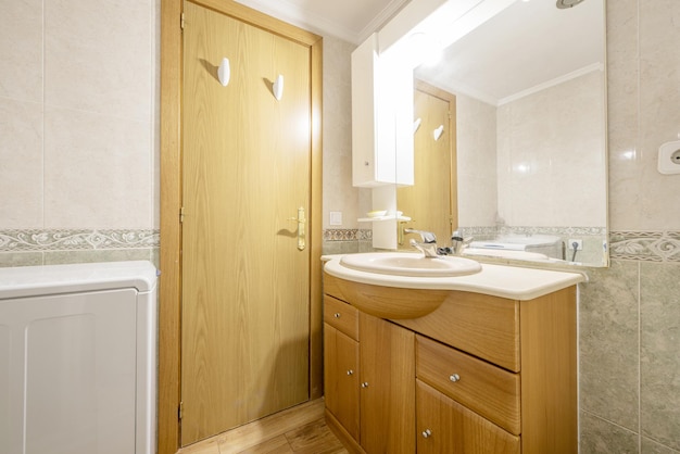 Bathroom with wooden bathroom cabinet with drawers and doors marble countertop and mirror with wall sconces