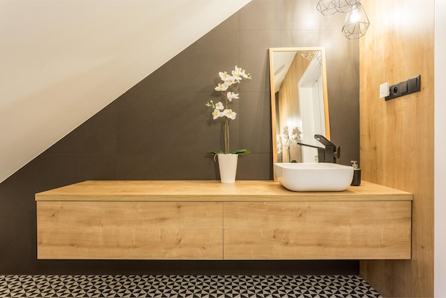 A bathroom with a wooden vanity and a mirror with a flower on it.