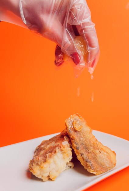 Battered fish fillet isolated over red background