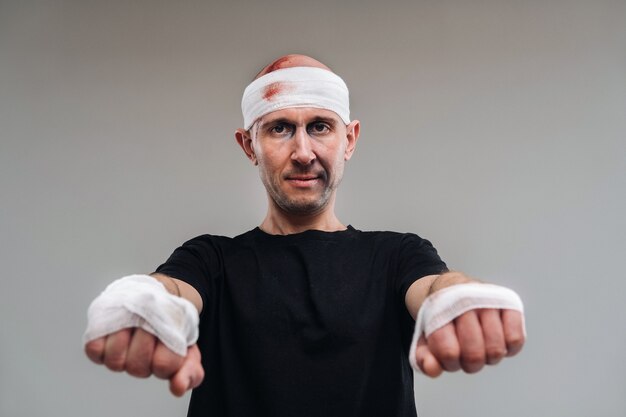 Battered man in a black Tshirt with his hands wrapped up