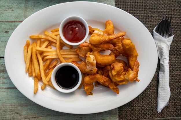 Battered prawns with chips on table