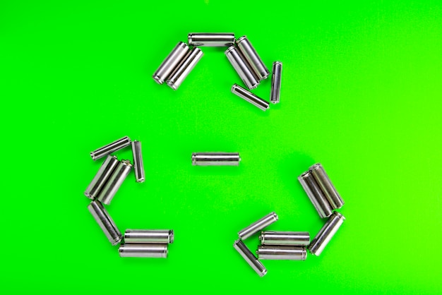 Batterijen in de vorm van recycling op groen. Batterij recycling, milieu concept.