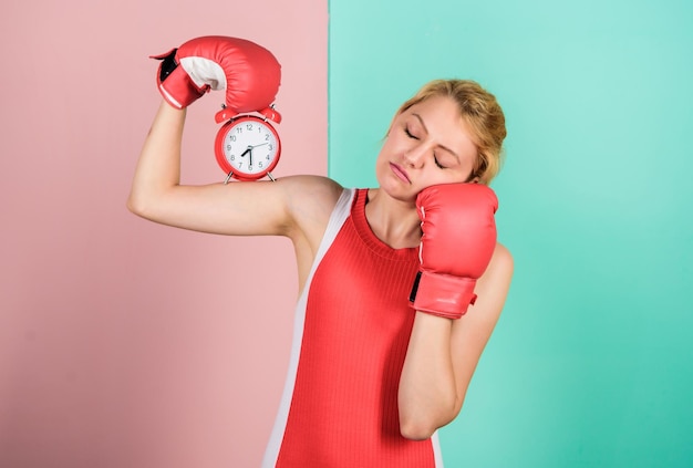 Battle for self discipline less of power activity time Establishing the clock time time to fight time for success sleepy woman boxing gloves girl boxer hold alarm clock morning energy