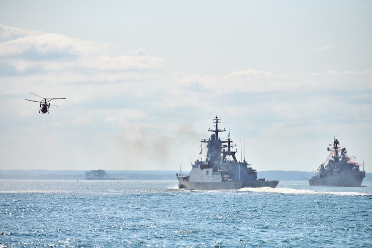 Photo battleships war ships corvette during naval exercises and helicopter maneuvering over water in baltic sea. warships, helicopters and boats perform tasks in sea, military warships sailing, russian navy